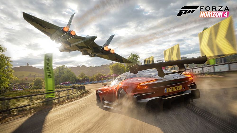 Jet flying low over a race car making a turn on a track.