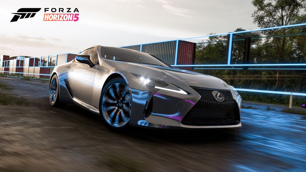 The silver 2021 Lexus LC 500 reflects blue neons attached onto shopping containers.