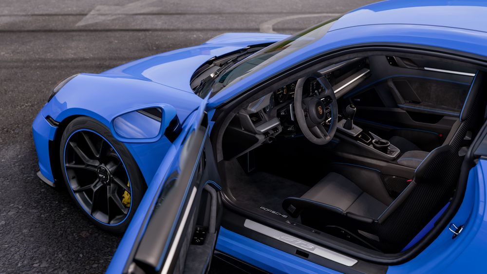 A view into the cabin of a Porsche 911 GT3 through its open driver door.