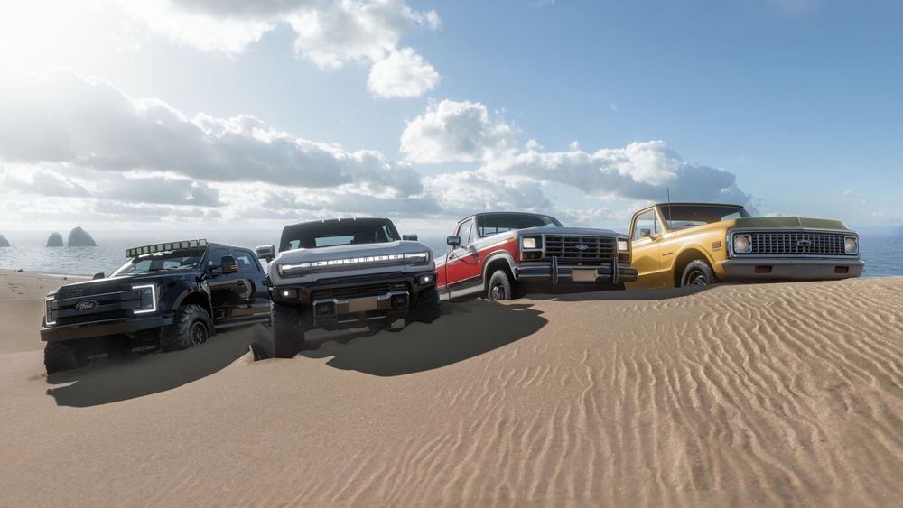 4 all-terrain vehicles on top of a sand dune