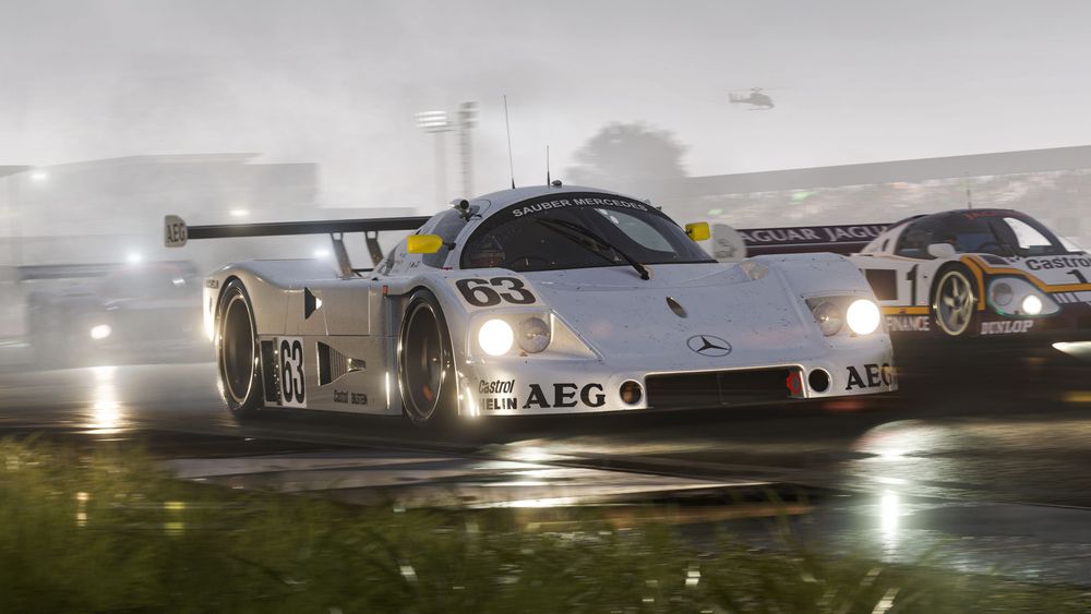 Silver 1989 Mercedes-Benz #63 Sauber-Mercedes C 9 racing in the rain at Silverstone alongside a purple and white 1988 Jaguar #1 Jaguar Racing XJR-9.