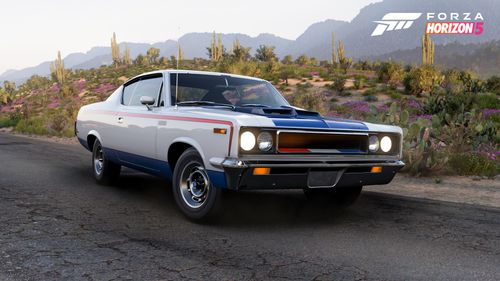 An AMC Rebel 'The Machine' is posed for a shot in front of a desert landscape.