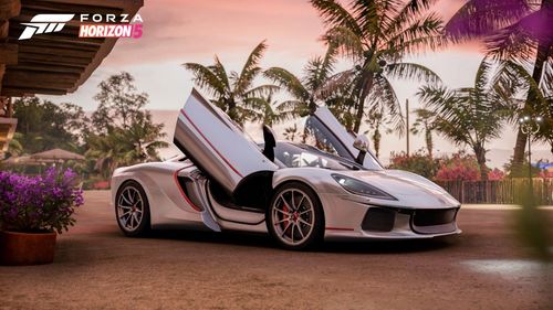 White sports car posed with its butterfly doors open on both sides.