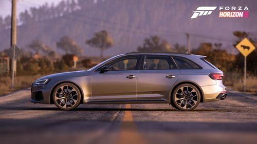 Side view of Audi car sitting across a two lane road.