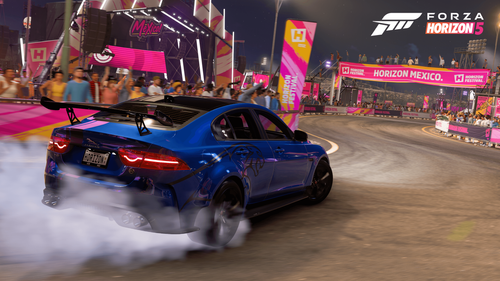 Blue Jaguar drifting trough a corner on a dusty race track