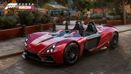 Bright red RP1 parked in front of a public park on a road