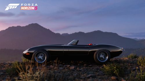 The 2012 Eagle Speedster parked in living desert with large rocks and boulders in the background.