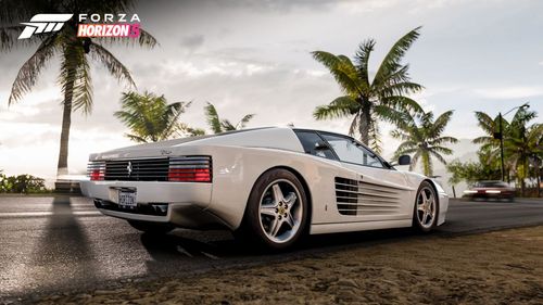 White Ferrari 512 TR driving down a coastal road.