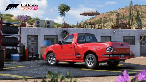 Ford F150 SVT Lightning parked outside a car maintenance shop.