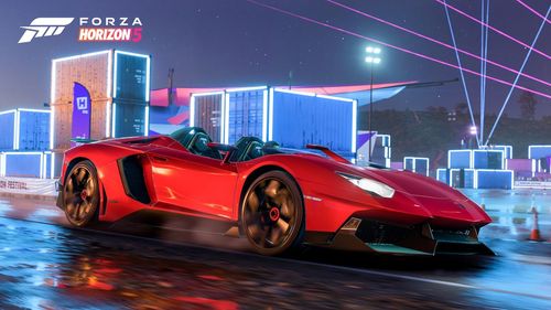 Lamborghini Aventador J speeding down a slippery road with neon lights in the background.