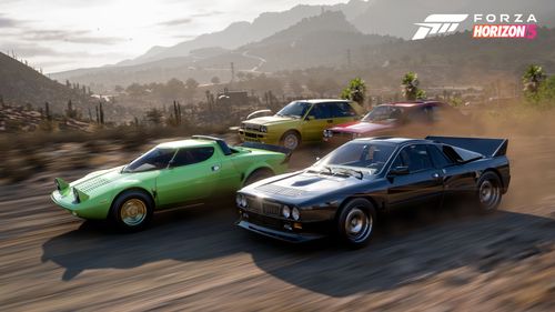 Four cars crossing a dirt road with hills and vegetation in the background