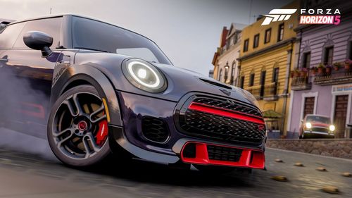 The front of a black modern Mini Cooper with its wheel turned inwards in the city of Guanajuato.