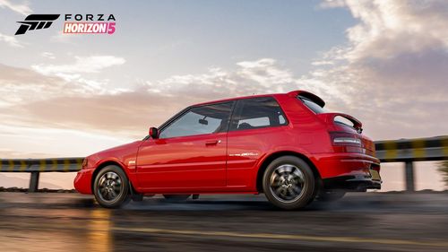 Mazda 323 GTR zooming down a cliff road.