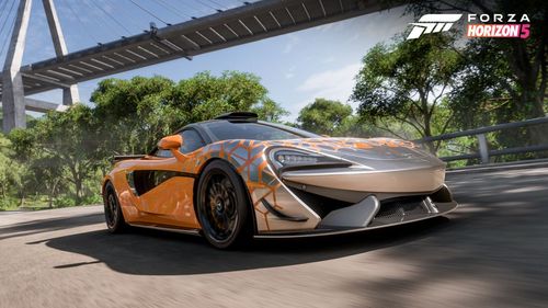 McLaren 620R parked outside under a suspension bridge.