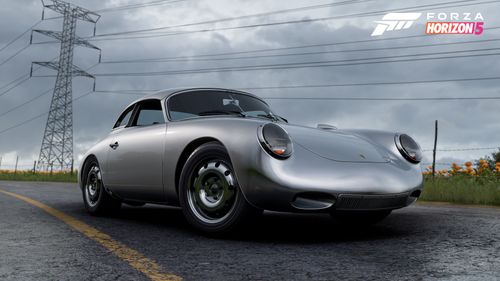 A silver Porsche 356 classic sports car parked on the road by a field as the sky turns grey, suggesting a storm is imminent.