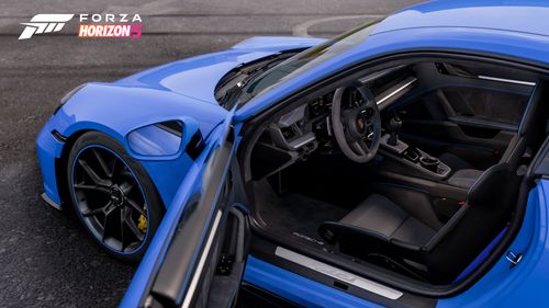 A view into the cabin of a Porsche 911 GT3 through its open driver door.