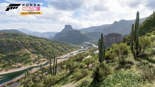 A view stretching out for miles of open spaces in the Green Hills  full of vibrant plant life, towering rock terrain and a crystal-clear stream of water.
