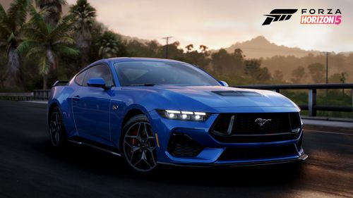 Ford Mustang driving on an asphalt road surrounded by foliage during the sunset