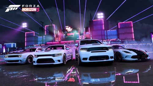 A group of all white Dodge cars are parked in front of a laser show at a festival site at night.