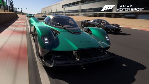 Aston Martin Valkyrie rushing through a straight section of a race track close to the curb