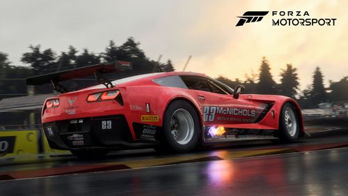 A Corvette with fire coming out of its sides cruising through a wet Road America