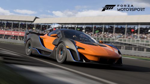 McLaren Sabre exiting a corner on the Silverstrone track in front of the crowd.
